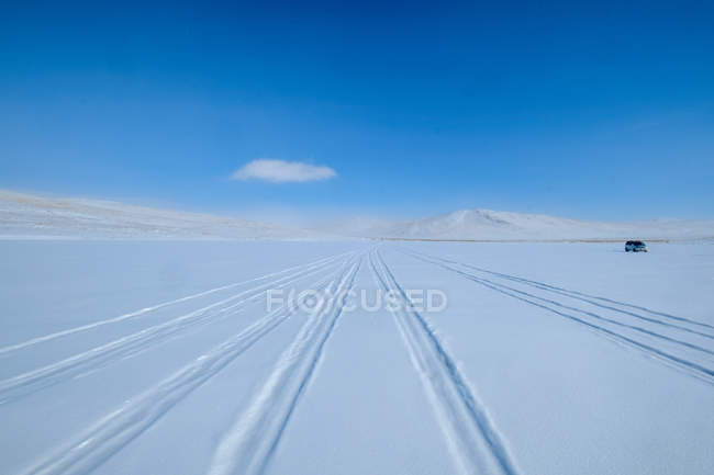 Trilhas de pneus na neve e um veículo estacionado, Baikal Lake, Irkutsk Oblast, Sibéria, Rússia — Fotografia de Stock