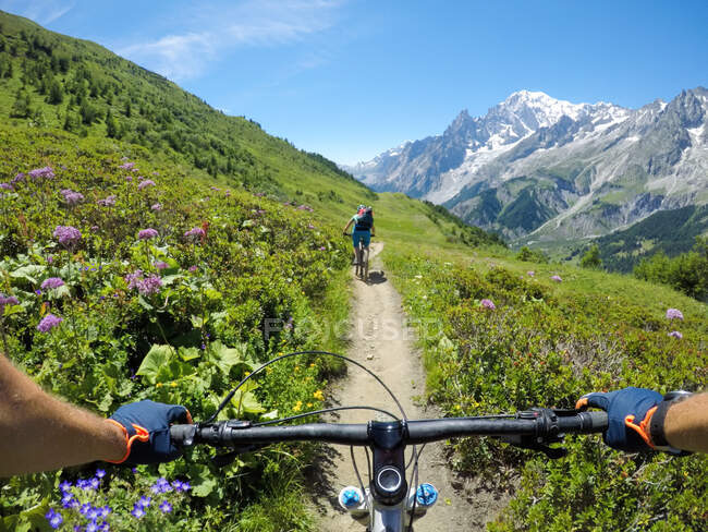 Due persone in mountain bike nelle Dolomiti, Val D'Aosta, Cormayeur, Italia — Foto stock