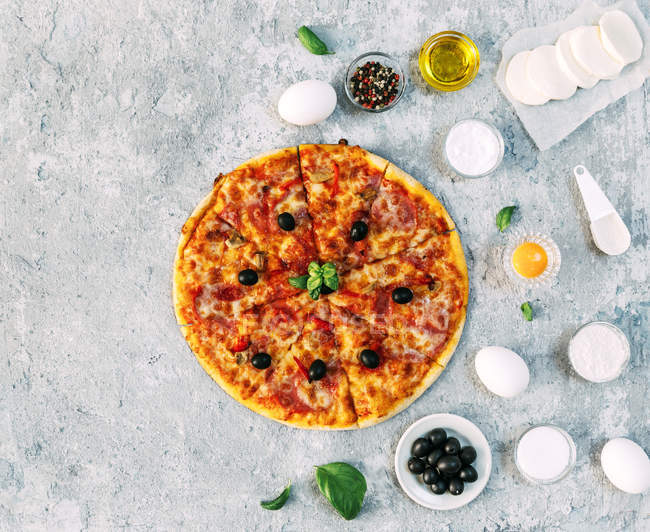 Овощная пицца в окружении свежих ингредиентов — стоковое фото