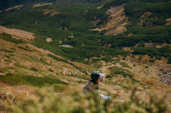 Mujer sentada en una ladera de montaña, Ucrania - foto de stock