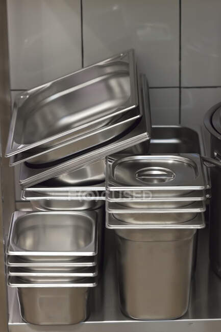 Pila de recipientes metálicos en una cocina comercial - foto de stock