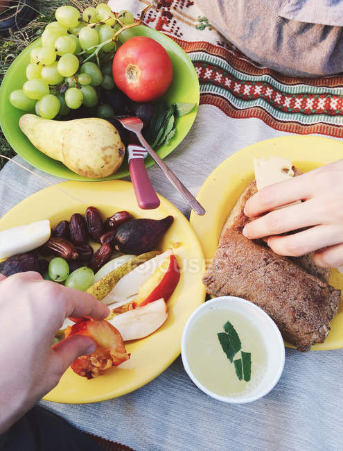 Due persone che mangiano cibo da picnic — Foto stock