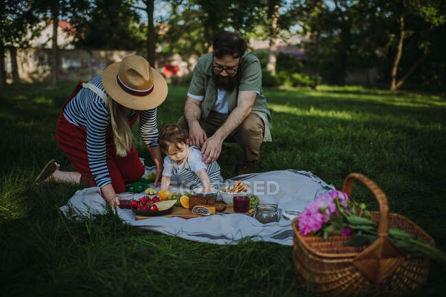 Família com um filho fazendo um piquenique — Fotografia de Stock