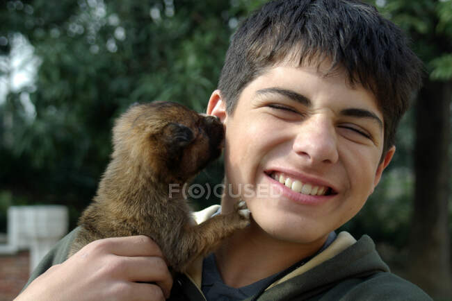 Stray puppy dog licking a boy's ear, India — Foto stock