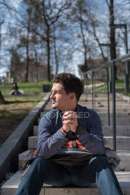 Чоловік сидить на сходах у громадському парку — стокове фото