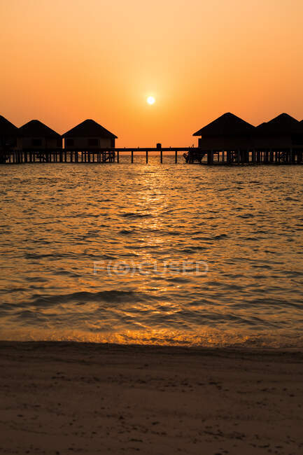 Красивий пейзаж моря з хатинками на заході сонця — стокове фото