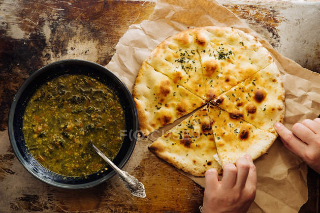 Cropped image of woman eating vegetable soup with flatbread — Stock Photo