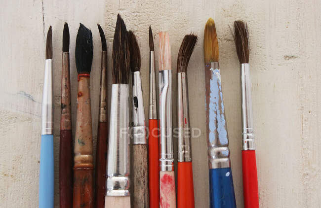 Row of paint brushes on a table — Stock Photo