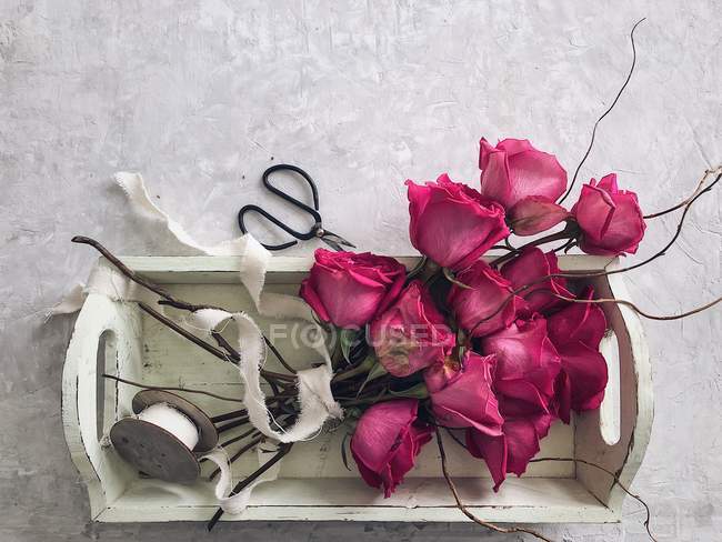 Buquê de rosas em uma bandeja com fita e tesoura — Fotografia de Stock
