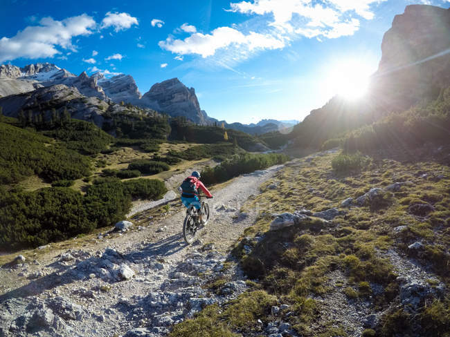 Mujer montando bicicleta de montaña en el Parque Nacional Fanes Sennes, Italia - foto de stock