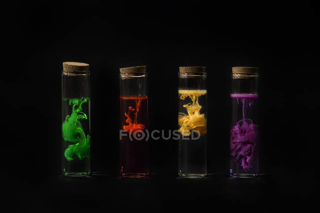 Tubos de ensaio cheios de água e tinta acrílica multicolorida — Fotografia de Stock