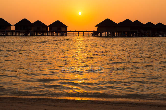 Silhouette di bungalow in legno in acqua di mare, Maldive — Foto stock