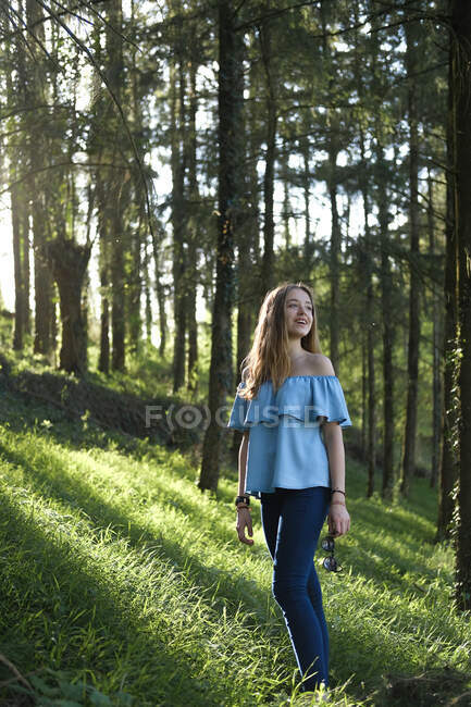 Adolescente de pie en el bosque, Cherveux, Nouvelle-Aquitania, Francia - foto de stock