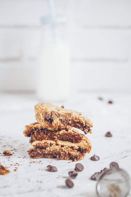 Three pieces of chocolate chip cookies and a bottle of milk — Stock Photo