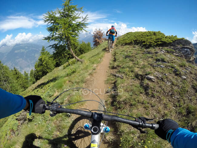 Dos personas en bicicleta de montaña en Dolomites, Val D 'Aosta, Italia - foto de stock