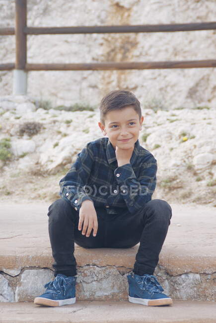 Retrato de um menino sorridente sentado em um degrau, Málaga, Andaluzia, Espanha — Fotografia de Stock