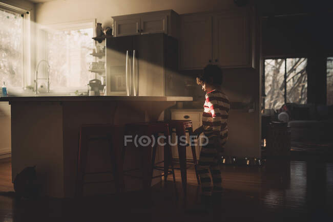 Ragazzo che balla in cucina alla luce del sole — Foto stock