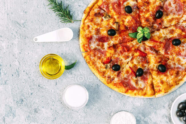 Vegetable pizza surrounded by fresh ingredients, top view — Stock Photo