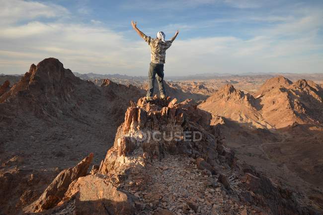 Людина стоїть на вершині гори з витягнутими руками, Індійський прохід Пустеля, Каліфорнія, Америка, Уса — стокове фото