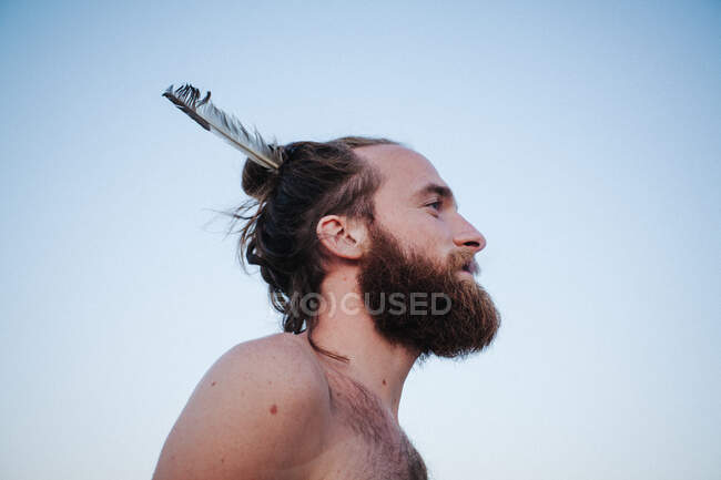 Портрет красивого мужчины с пером в верхнем узле — стоковое фото