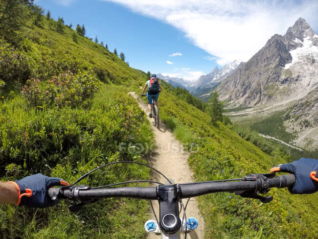 Due persone in mountain bike nelle Dolomiti, Val D'Aosta, Cormayeur, Italia — Foto stock