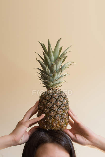 Woman holding a pineapple on her head — Stock Photo