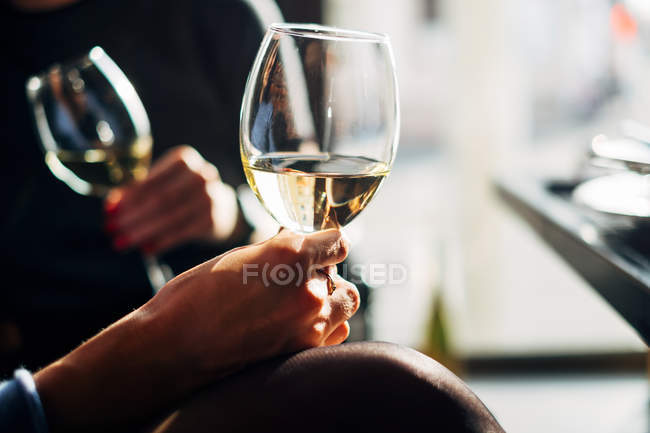 Dos mujeres sentadas en una mesa disfrutando de una copa de vino - foto de stock