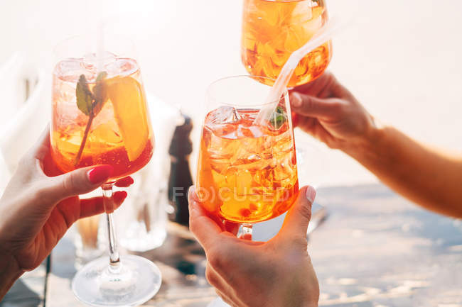 Drei Frauen stoßen mit Aperol-Spritz-Cocktails feierlich an — Stockfoto