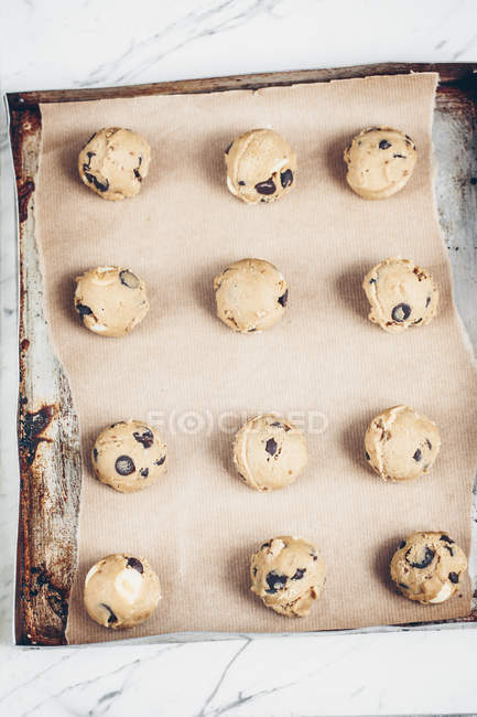 Boules de pâte à biscuits sur une plaque à pâtisserie — Photo de stock
