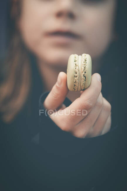 Garçon tenant un macaron — Photo de stock