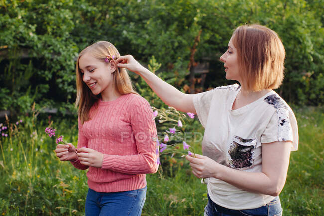 Mutter steckt ihrer Tochter eine Blume ins Haar — Stockfoto