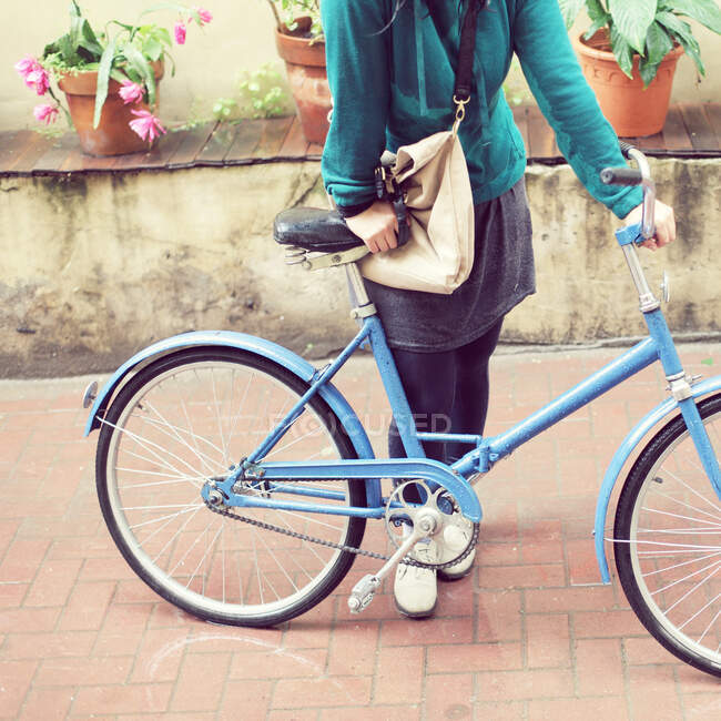 Cropped shot of Woman standing with a bicycle — Stock Photo