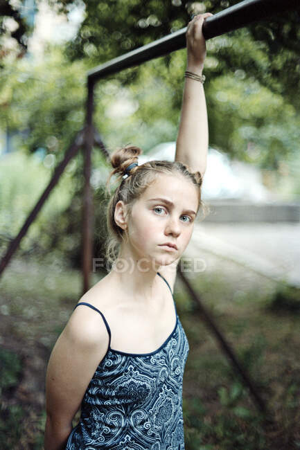 Girl hanging from a metal bar — Stock Photo