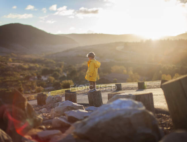 Boy standing on wooden post in a rural landscape, Orange County, California, Stati Uniti — Foto stock