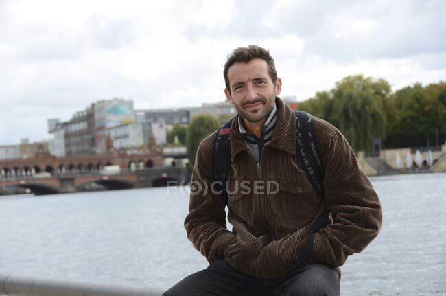 Portrait of a man sitting in front of Oberbaum Bridge, Berlin, Germany — Stock Photo