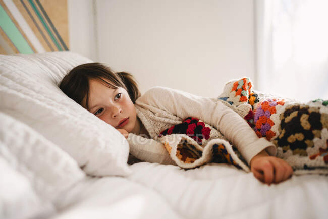 Portrait d'une jeune fille sur un lit — Photo de stock