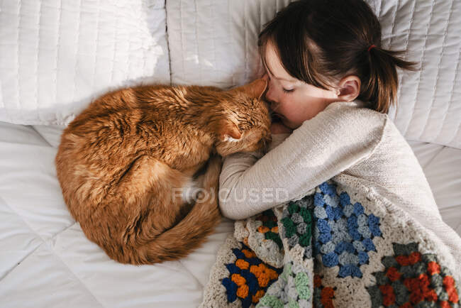Junges Mädchen schläft auf Bett mit Katze — Stockfoto