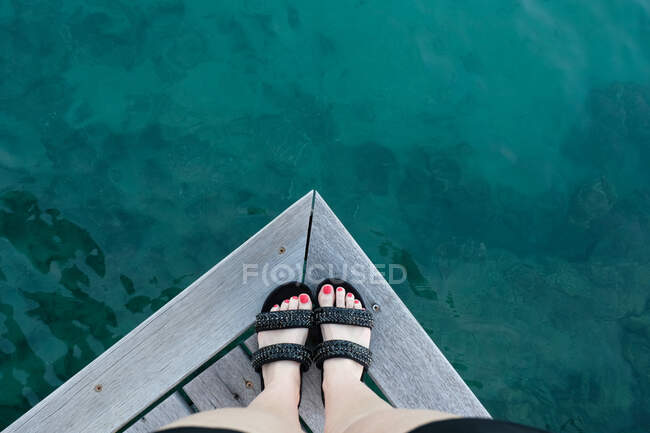 Close-up de pés de uma mulher em pé na borda de um molhe de madeira, Taiti, Polinésia Francesa — Fotografia de Stock