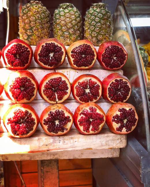 Pomegranate and pineapples in a street market — Stock Photo