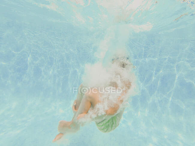 Хлопчик стрибає в басейн — стокове фото
