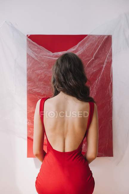 Porträt einer Frau, die an einer roten Wand steht — Stockfoto