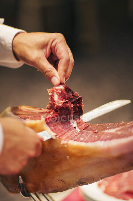 Chef cutting prosciutto meat, cropped shot — Stock Photo
