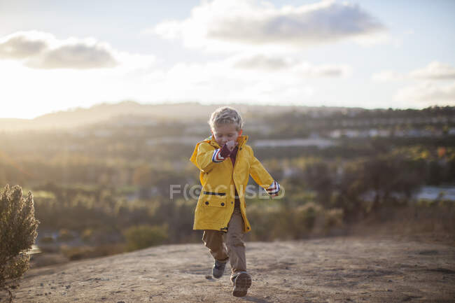 Boy running in rural landscape, Condado de Orange, California, Estados Unidos - foto de stock