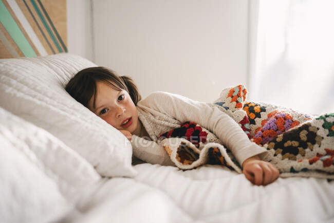 Ritratto di giovane ragazza su un letto — Foto stock