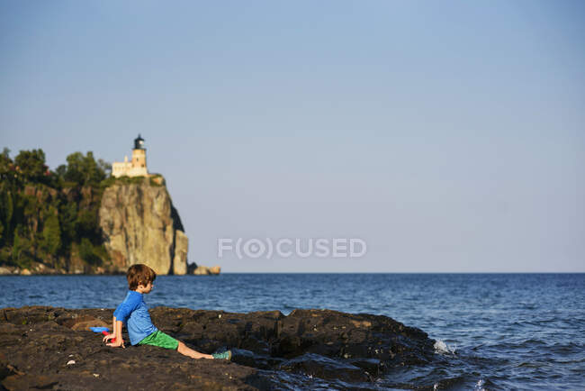 Junge spielt in der Nähe eines Sees — Stockfoto
