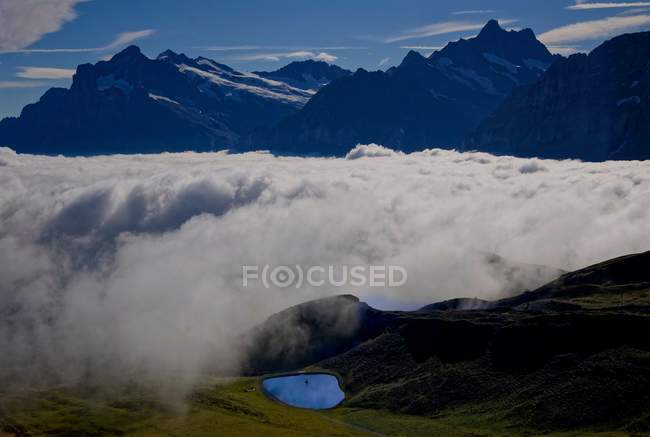 Живописный вид на облачный ковер в горах, Маннлихен, Гриндельвальд, Берн, Швейцария — стоковое фото