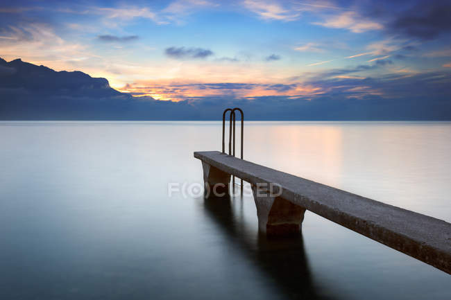 Ponton en pierre au coucher du soleil, Lac Léman, Haute-Savoie, France — Photo de stock