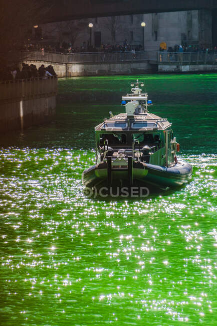 Лодка, плывущая вдоль реки Чикаго в День Святого Патрика, Чикаго, штат Иллинойс, США — стоковое фото