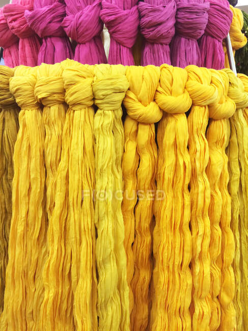 Cuadro completo tiro de bufandas amarillas y púrpuras en el mercado - foto de stock