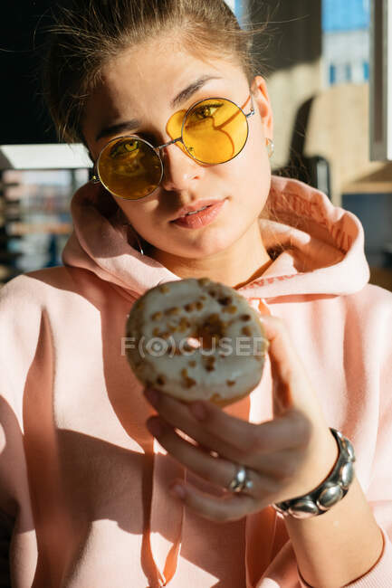 Portrait of a woman holding a doughnut — Stock Photo